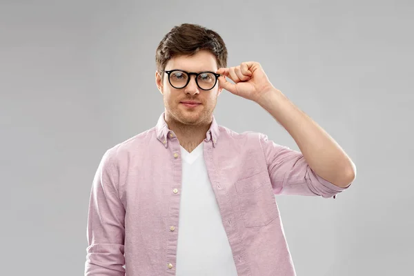 Joven en gafas sobre fondo gris —  Fotos de Stock