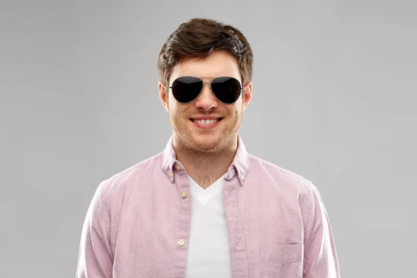 Lachende jongeman in shirt en aviator zonnebril — Stockfoto