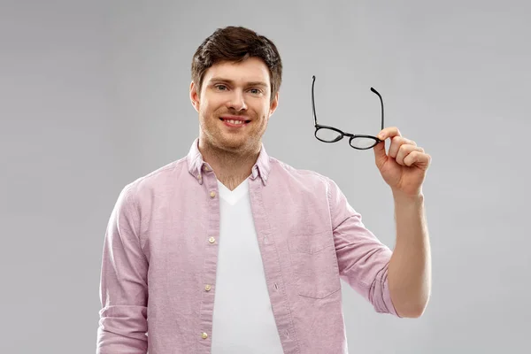 Sorrindo homem com óculos sobre fundo cinza — Fotografia de Stock