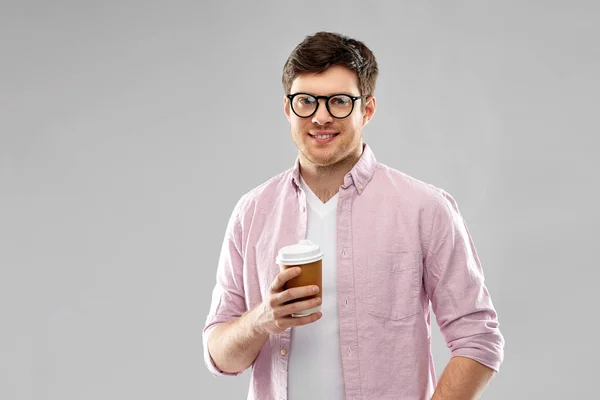 Молодой человек или студент в очках пьет кофе — стоковое фото