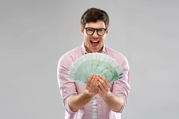 Joven feliz en gafas con ventilador del dinero del euro — Foto de Stock