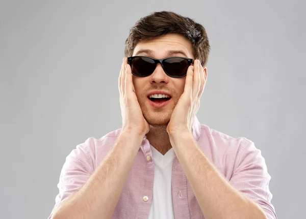 Jeune homme étonné en lunettes de soleil noires — Photo