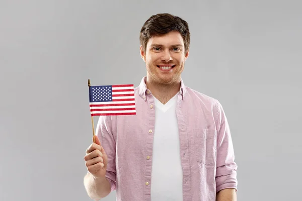 Gelukkig mens met Amerikaanse vlag over grijze achtergrond — Stockfoto