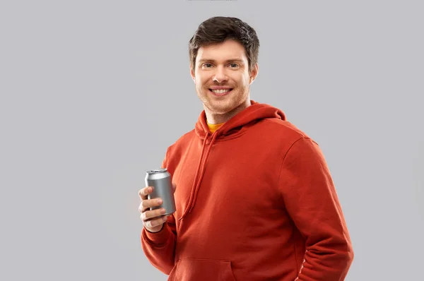 Щасливий молодий чоловік п'є соду з бляшанки — стокове фото