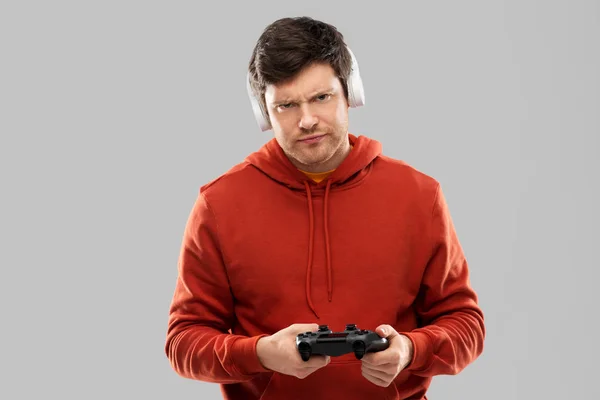 Рассеянный мужчина с геймпадом играет в видеоигру — стоковое фото