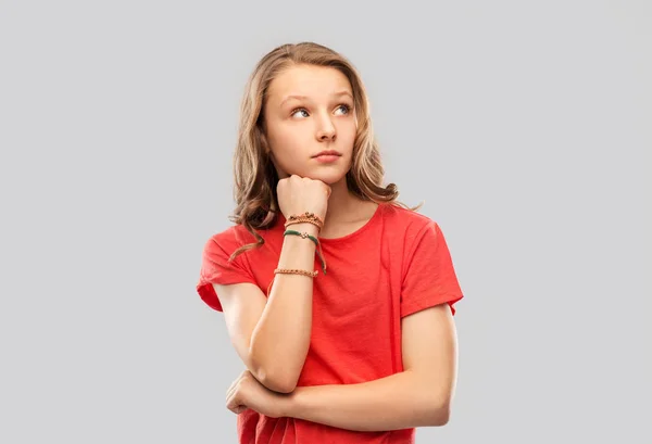 Девушка-подросток в красной футболке с браслетами на руке — стоковое фото