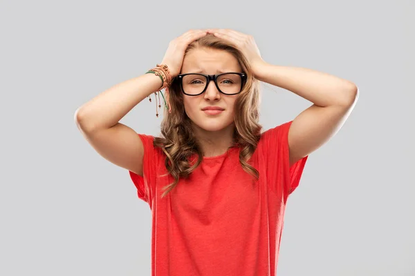 Απελπισμένος εφηβικό κορίτσι με τα γυαλιά, κρατώντας το κεφάλι — Φωτογραφία Αρχείου