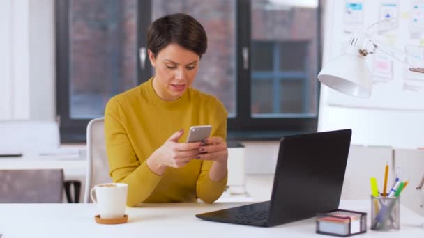 Glimlachende zakenvrouw met smartphone op kantoor — Stockvideo