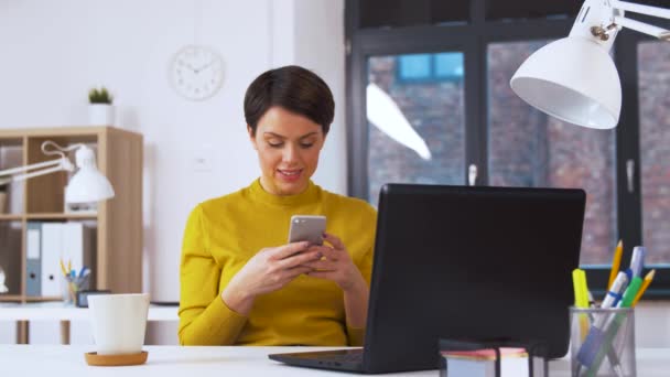 Gülümseyen iş kadını ofiste Smartphone kullanarak — Stok video