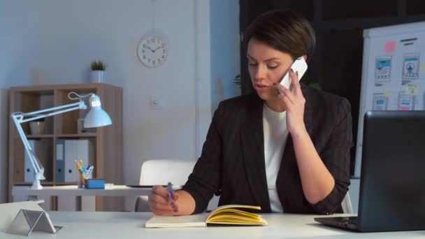 Business woman calling on smartphone at dark office — стоковое видео