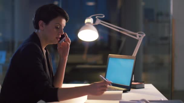 Business woman calling on smartphone at dark office — стоковое видео