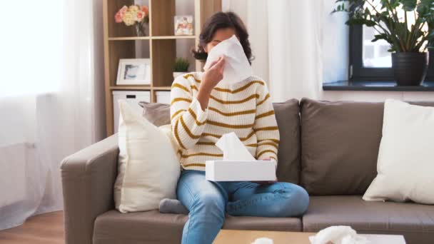 Sick woman blowing nose in paper tissue at home — Stock Video