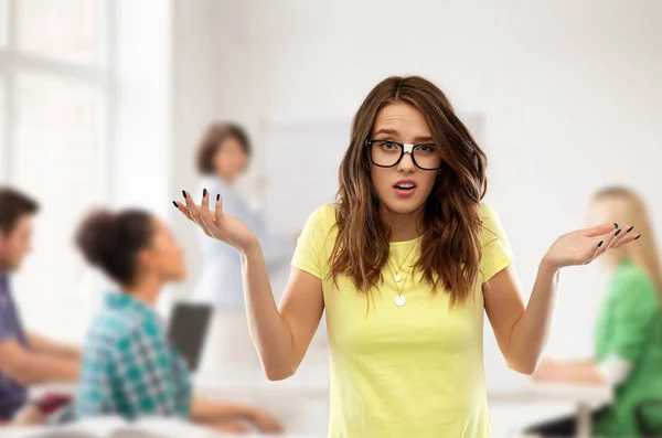 Confused teenage student girl in glasses at school — Stock Photo, Image
