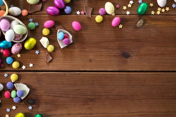 Huevos de chocolate y gotas de caramelo en mesa de madera — Foto de Stock