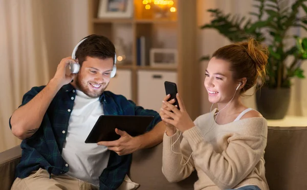 Pareja con gadgets escuchando música en casa —  Fotos de Stock