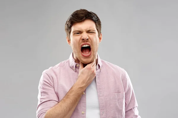 Hombre gritando que sufre de dolor de garganta —  Fotos de Stock