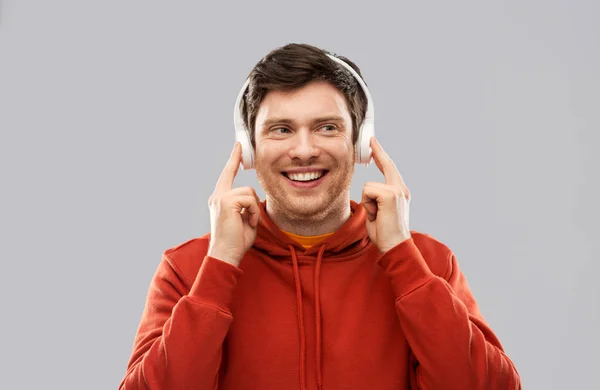 Joven feliz en auriculares y sudadera con capucha roja — Foto de Stock
