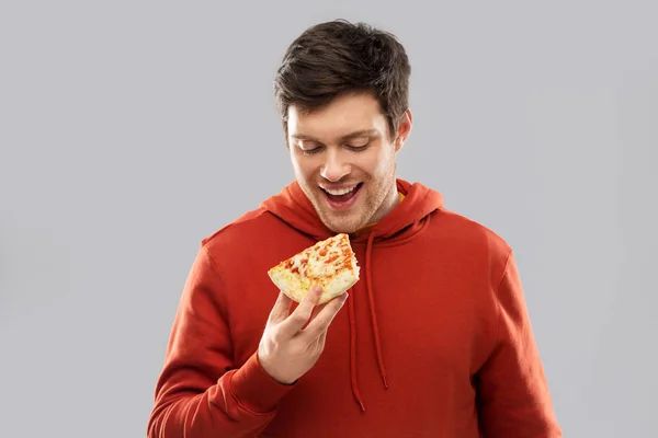 Happy young man eating pizza — Stock Photo, Image