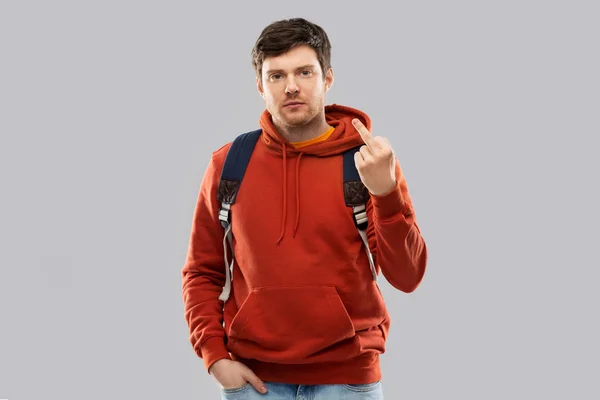 Manlig student med väska visar långfingret — Stockfoto