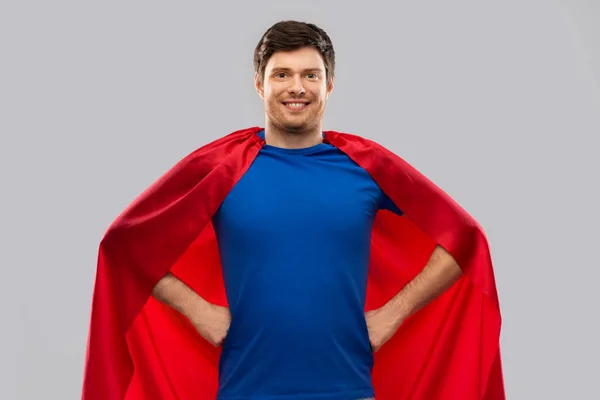 Man in red superhero cape over grey background — Stock Photo, Image