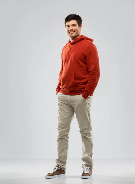 Молодий чоловік в червоному светрі на сірому фоні — стокове фото