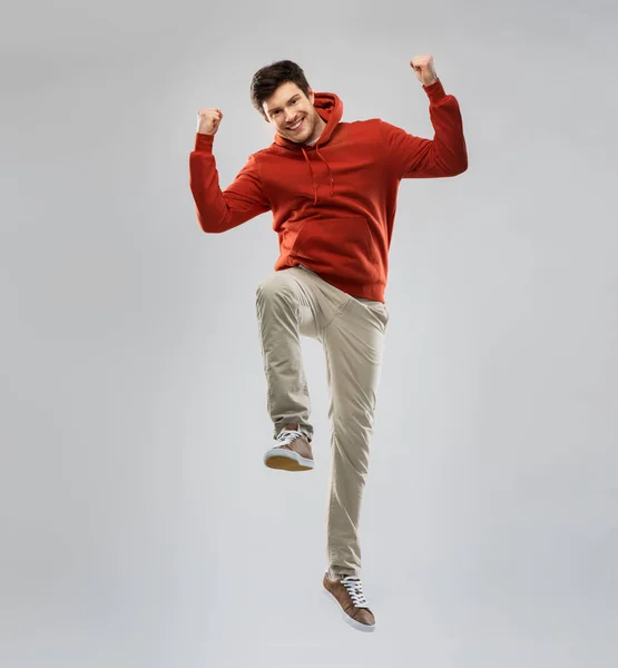 Homem com capuz pulando e celebrando o sucesso — Fotografia de Stock