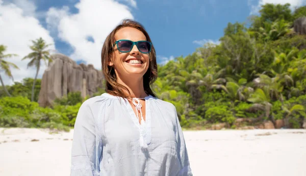 Mujer sonriente feliz en gafas de sol sobre la playa —  Fotos de Stock