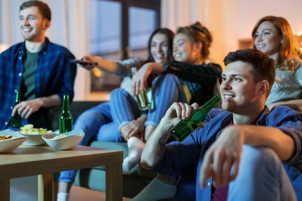 Amigos felices con bebidas viendo la televisión en casa —  Fotos de Stock
