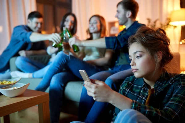 Triste mujer joven con teléfono inteligente en la fiesta en casa — Foto de Stock