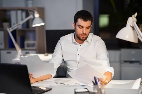 Uomo d'affari con documenti che lavorano all'ufficio notturno — Foto Stock