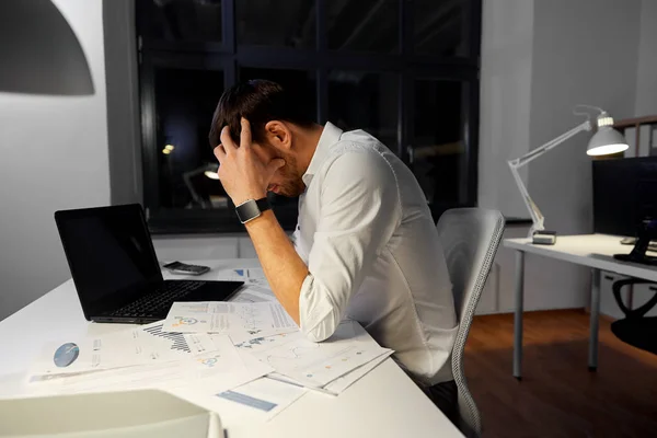 Hombre de negocios con papeles trabajando en la oficina nocturna — Foto de Stock