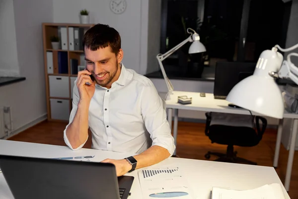Businessman calling on smartphone at night office — Stock Photo, Image