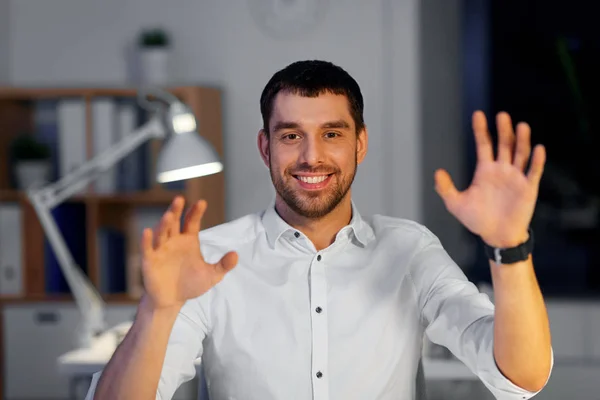 Businessman using gestures at night office — Stock Photo, Image