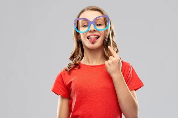 Teenage girl with party prop showing tongue — Stock Photo, Image