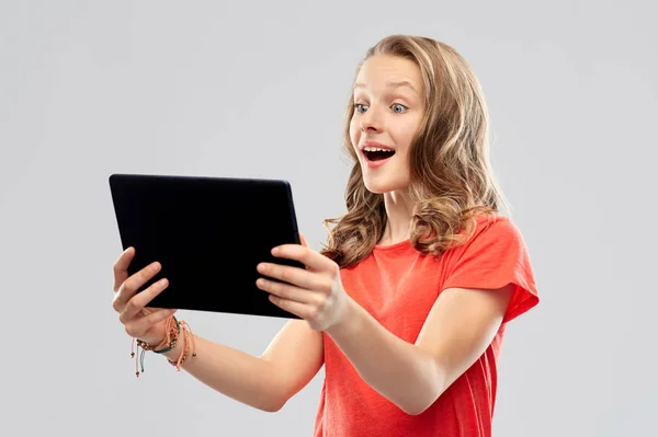 Erstauntes Teenager-Mädchen mit Tablet-Computer — Stockfoto