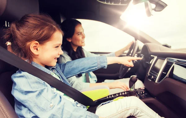 Mujer feliz con un niño pequeño conduciendo en coche — Foto de Stock