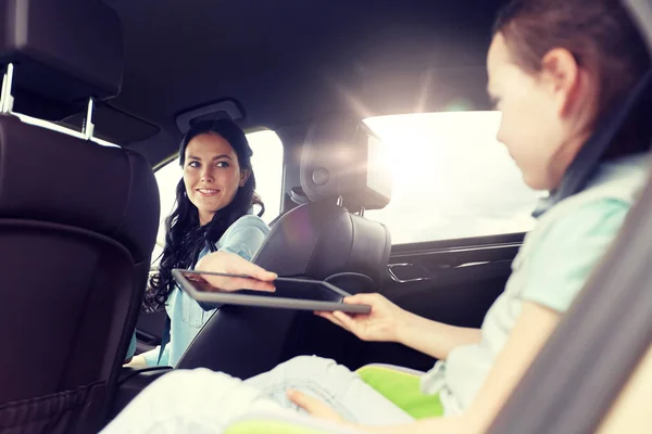 Família feliz com tablet pc dirigindo no carro — Fotografia de Stock