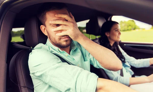 Woman driving car and man covering face with palm — Stock Photo, Image