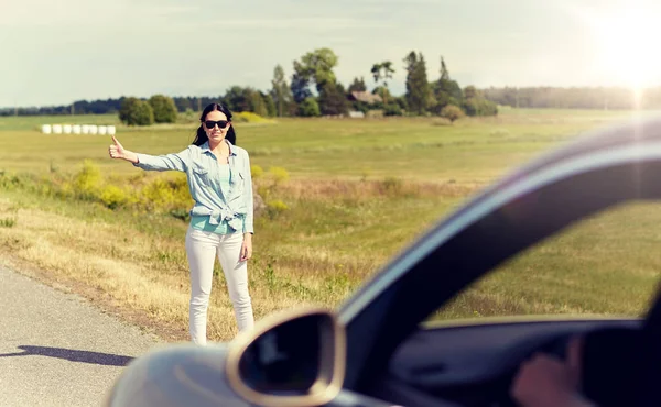 Mujer autostop y autostop en el campo — Foto de Stock