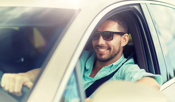 Счастливый улыбчивый мужчина в солнцезащитных очках за рулем автомобиля — стоковое фото
