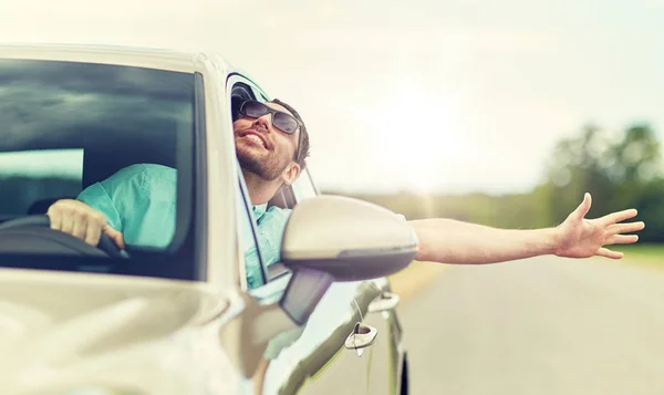Счастливый человек в тенях за рулем автомобиля и размахивающей рукой — стоковое фото