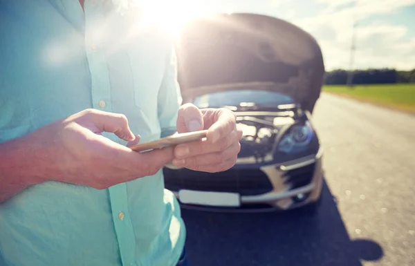 Nahaufnahme eines Mannes mit Smartphone und kaputtem Auto — Stockfoto