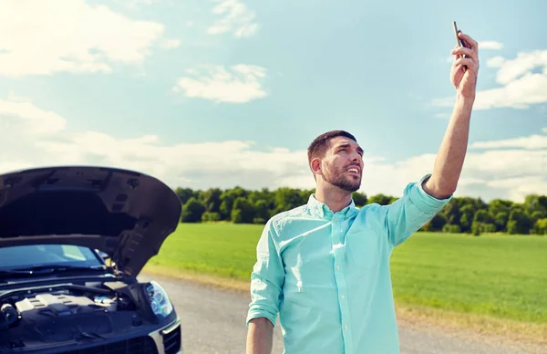 Mann mit Smartphone und kaputtem Auto auf dem Land — Stockfoto