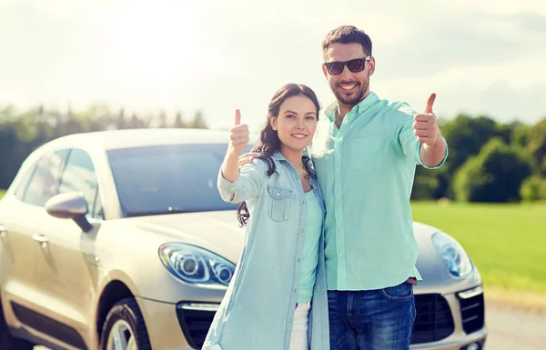 Feliz hombre y mujer mostrando pulgares hacia arriba en el coche — Foto de Stock