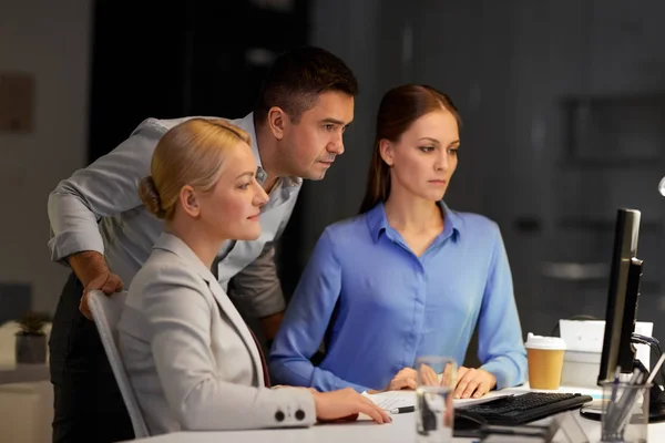 Business team with computer working late at office — Stock Photo, Image