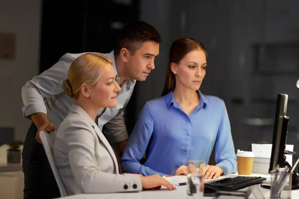 Geschäftsteam mit Computer arbeitet spät im Büro — Stockfoto