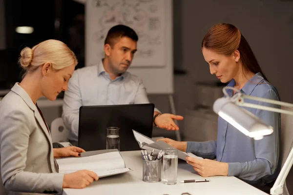 Business-team med laptop arbetar på natten kontor — Stockfoto