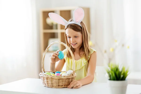 Happy girl with colored easter eggs at home — Stock Photo, Image