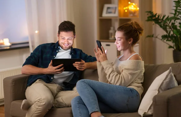 Casal com tablet computador e smartphone em casa — Fotografia de Stock