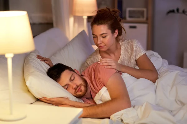 Frau weckt ihren schlafenden Mann zu Hause im Bett — Stockfoto